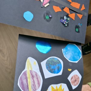 Dwie prace plastyczne na czarnym tle. G&oacute;rna przedstawia kosmiczną scenę z kolorowymi elementami, brokatem i pomarańczowymi tr&oacute;jkątami. Dolna to kolaż z wyklejonymi planetami o r&oacute;żnych kształtach i kolorach, niekt&oacute;re z nich błyszczące.